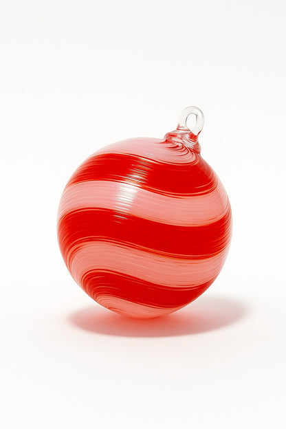 Hand-blown red and white striped glass ornament on a white background by Puget Sound Glassblowing Studio