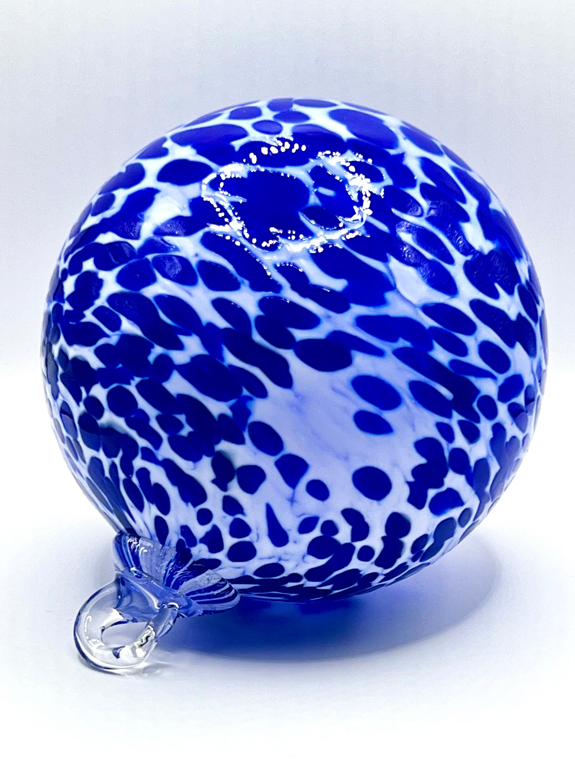 Hand-blown Cobalt blue spotted glass ornament with deep blue and white leopard-style pattern from Puget Sound Glassblowing Studio. 