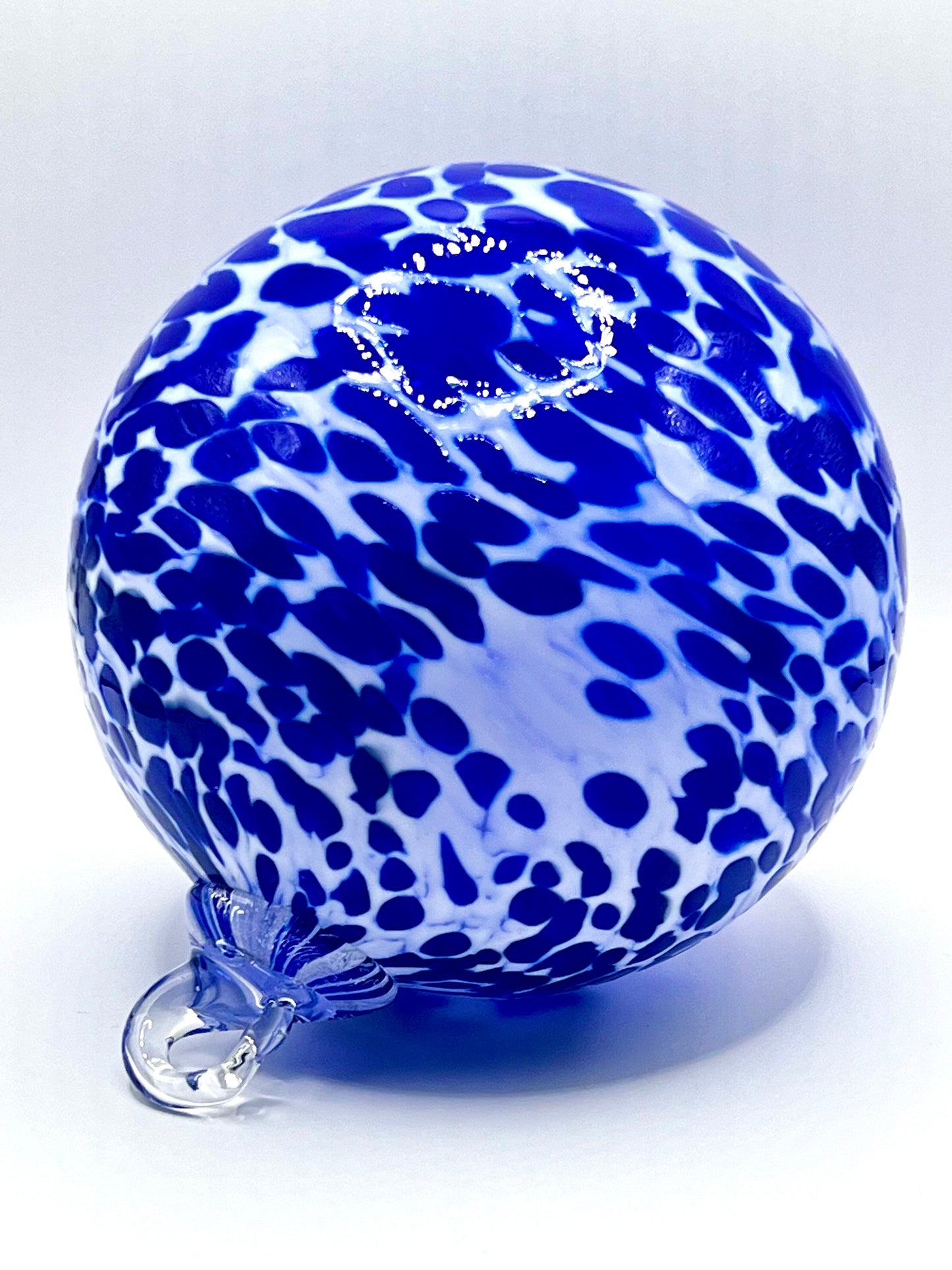 Blue and white hand-blown glass ornament with spotted pattern, by Puget Sound Glassblowing Studio.